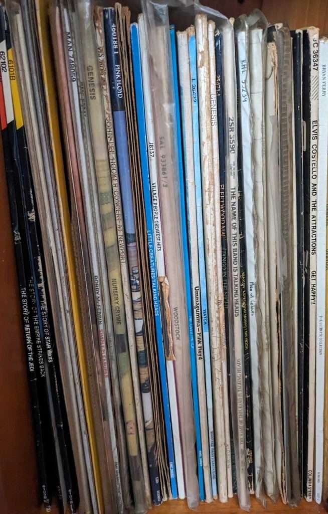 Close up of record album covers standing end on end, like books on a shelf.