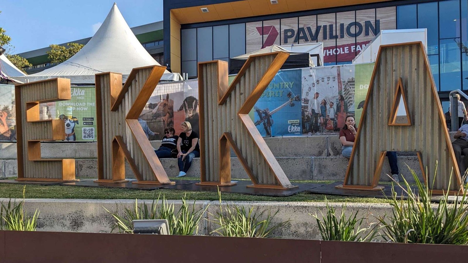 EKKA spelt out in large wooden and metal letters stands on a strip of grass at the RNA Showgrounds in Brisbane.