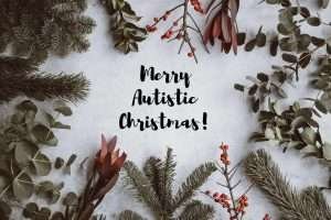 Christmas background - pine, eucalyptus, berries - with black text in the centre that reads Merry Autistic Christmas!